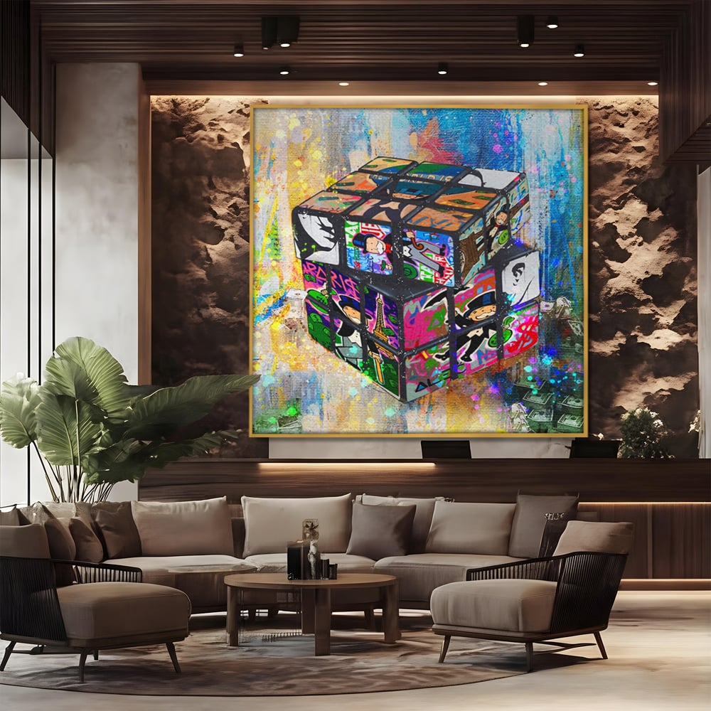 Tablou canvas cu pictura cub rubik cu monopol, in rama de aluminiu auriu, pe perete intr-un birou